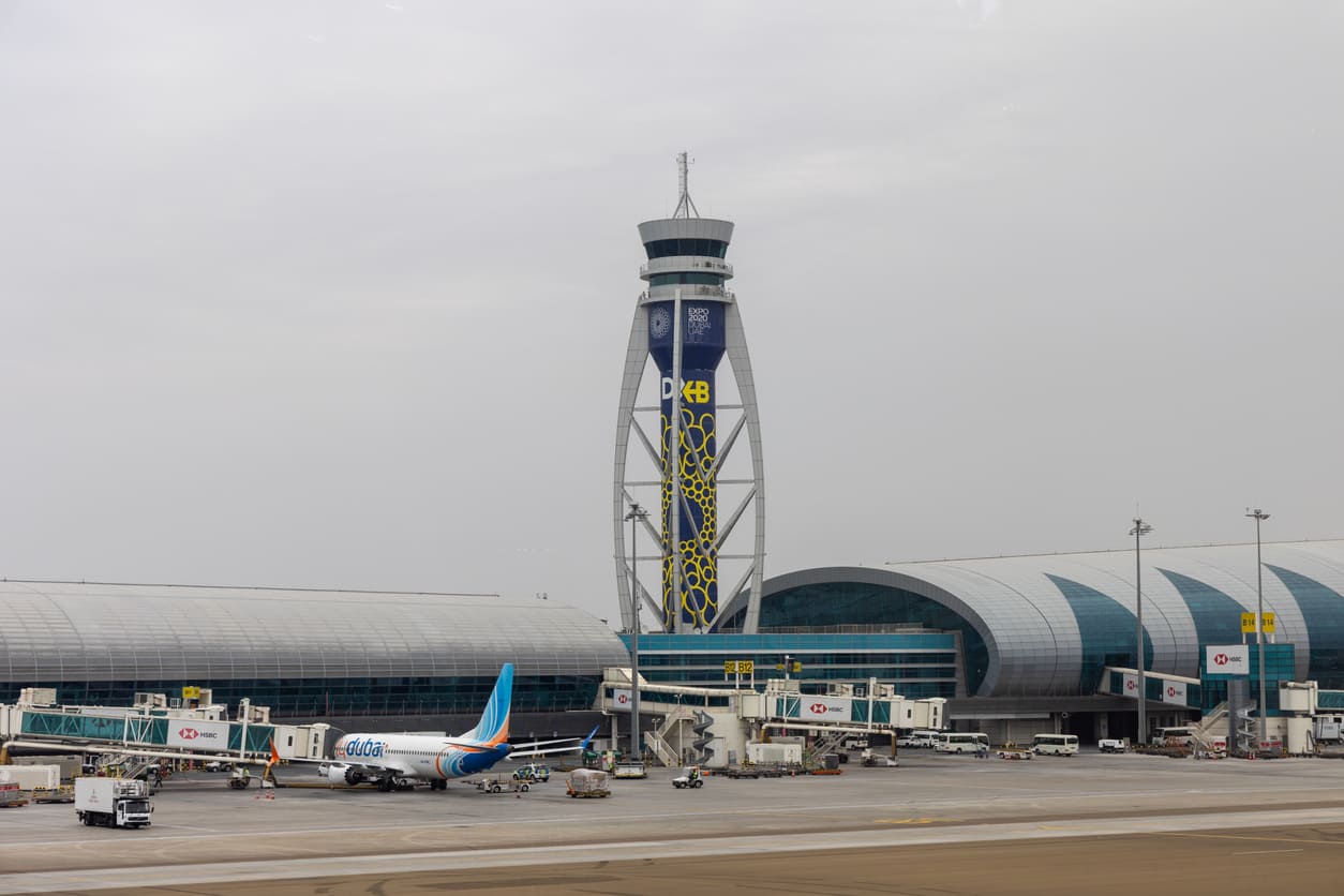 The air traffic control tower and sleek terminal buildings of Dubai International Airport highlight its modern design and global significance.