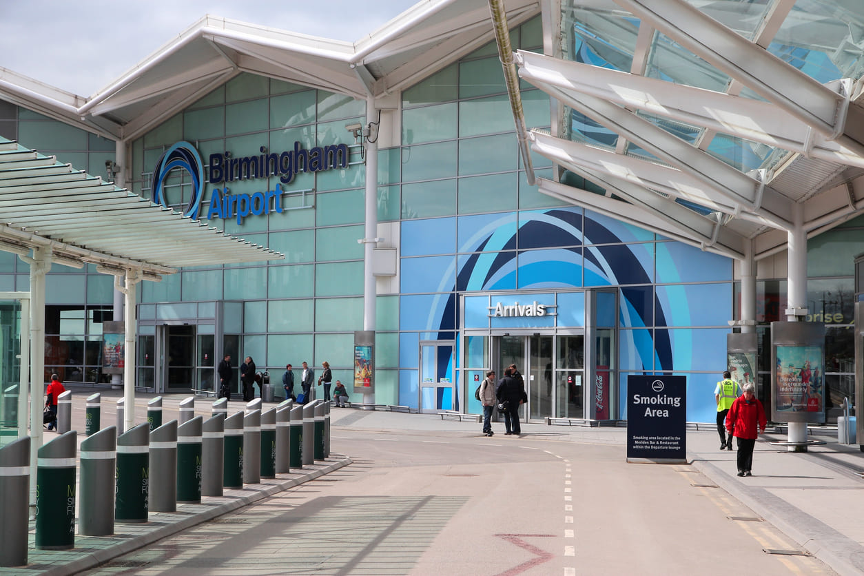 The entrance to Birmingham Airport's arrivals area, featuring sleek architecture and clear signage.