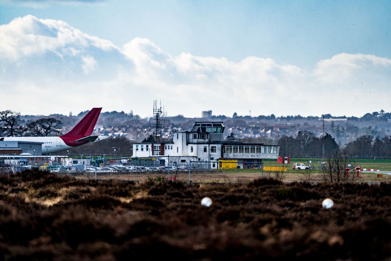 Bournemouth Airport's terminal and control tower, set against a backdrop of urban and natural surroundings.