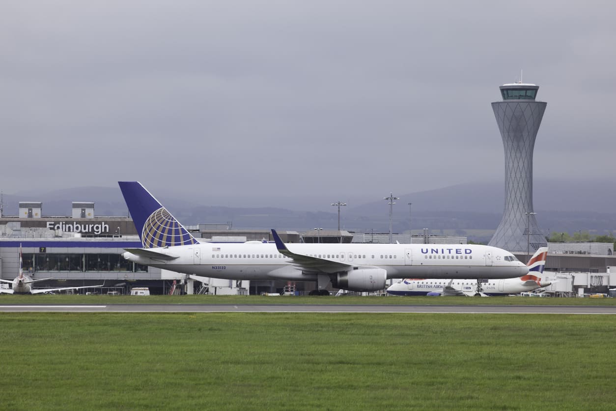 Edinburgh Airport featuring a United Airlines plane on the runway with the distinctive modern control tower in the background.