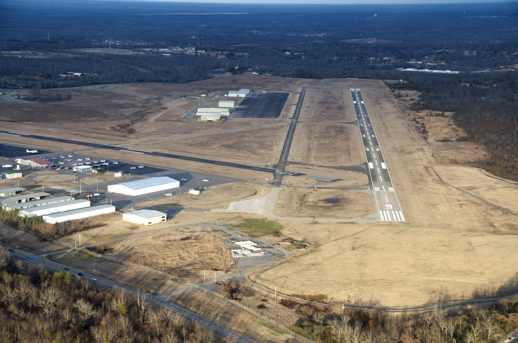 An aerial view of Arkansas International Airport showcases its expansive runway and facilities, reflecting its industrial and cargo-focused operations.