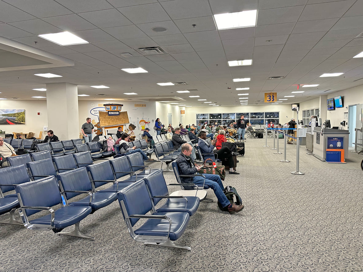 A spacious seating area at Bangor International Airport, with passengers waiting near the boarding gate in a calm, organized environment.