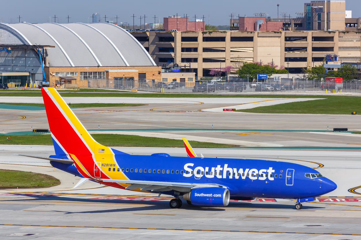 A Southwest Airlines aircraft positioned on the runway at Chicago Midway International Airport, with terminal buildings in the background.