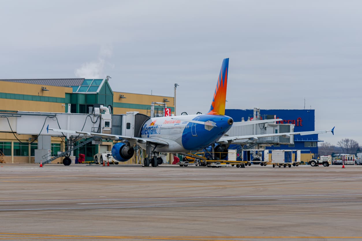 An Allegiant Air Airbus is parked at the gate at Chicago Rockford International Airport on a cloudy afternoon, ready for its next flight.