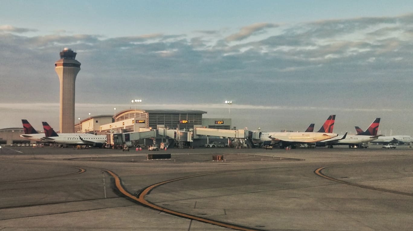 Bustling airside view of Detroit Metropolitan Airport, with Delta aircraft parked at modern gates under a serene sky.