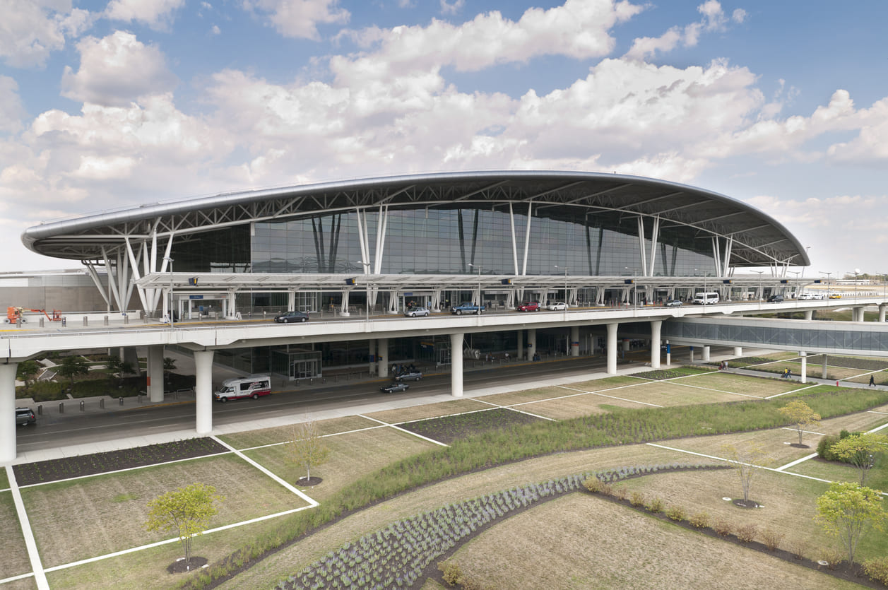 The modern and eco-friendly Indianapolis International Airport terminal, featuring sleek architecture, glass facades, and lush landscaping.