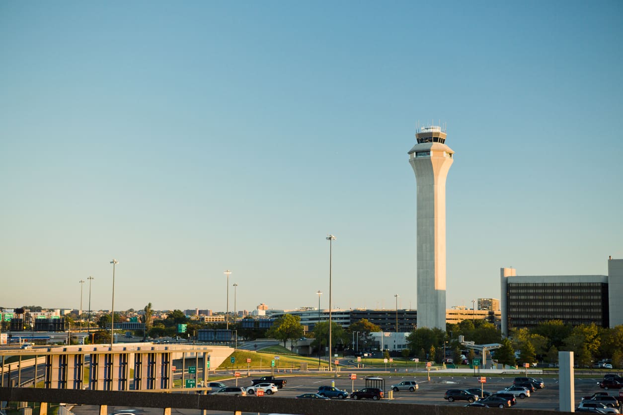 Newark Liberty International Airport's modern control tower surrounded by parking and terminal facilities.