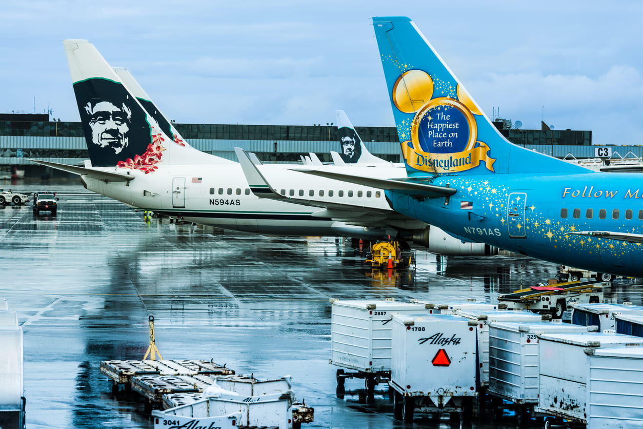 Alaska Airlines planes at Ted Stevens Anchorage International Airport, highlighting its bustling operations and vibrant livery designs.