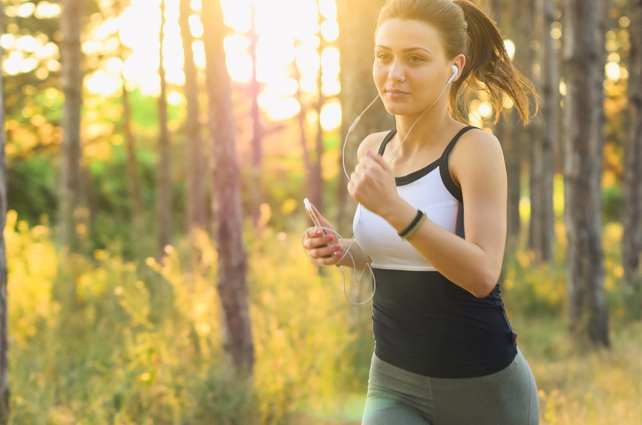 A young girl is running while listening to music.