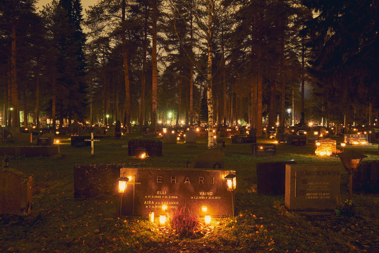 A Finnish cemetery gently illuminated by countless candles, symbolizing remembrance and quiet reflection on All Saints' Day.