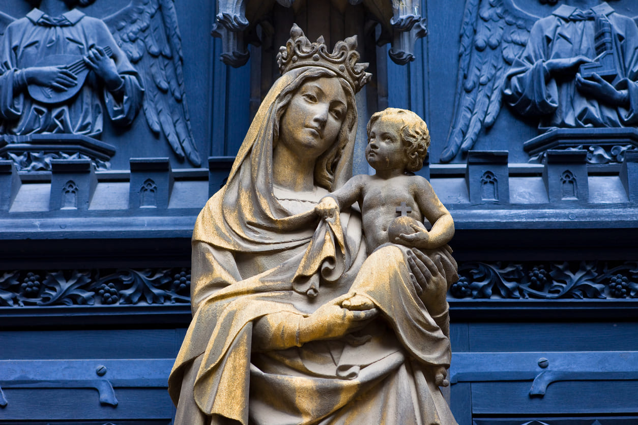 A statue of the Virgin Mary holding baby Jesus, symbolizing maternal devotion and faith.