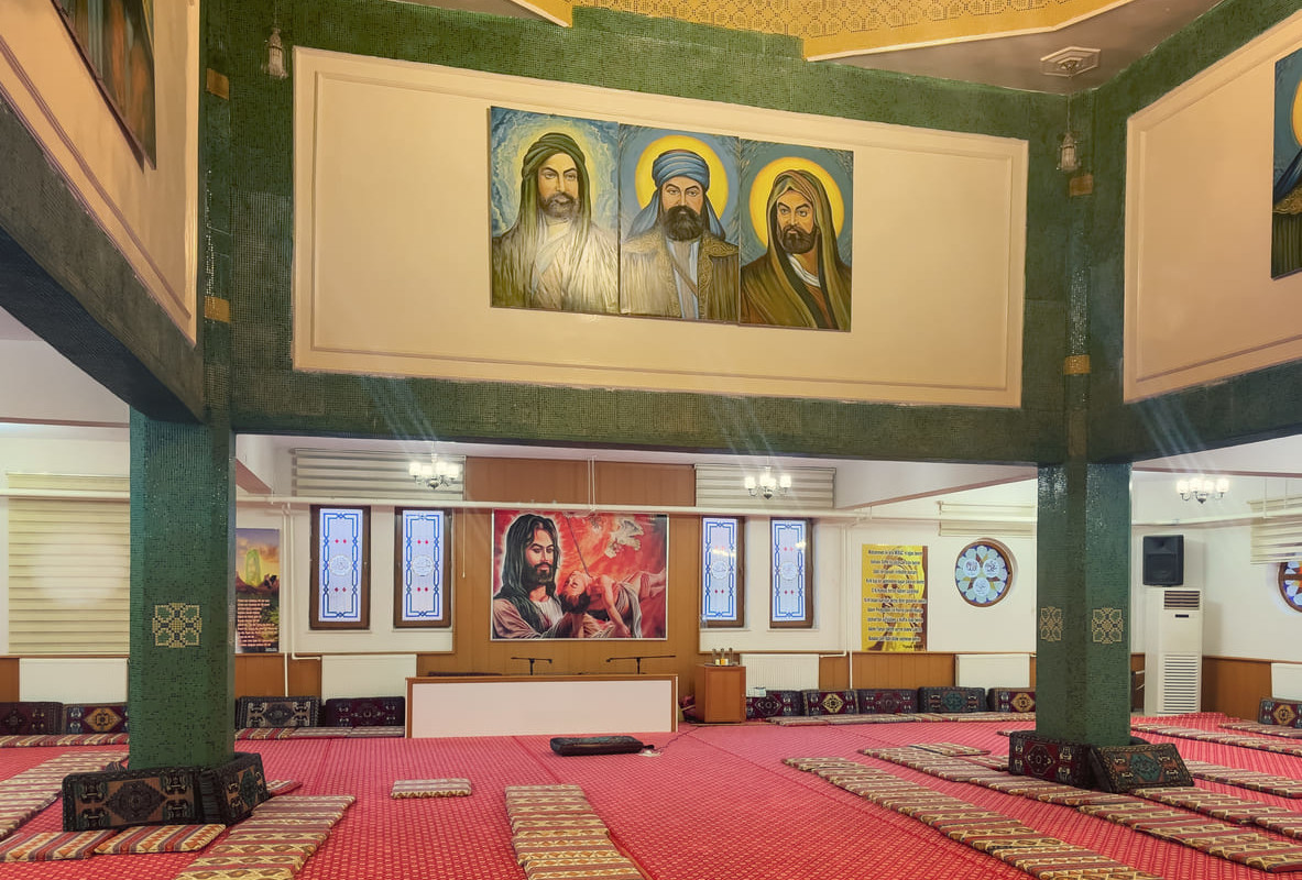 Interior of a cem house adorned with spiritual artwork, offering a space for Alevi worship and communal gatherings.