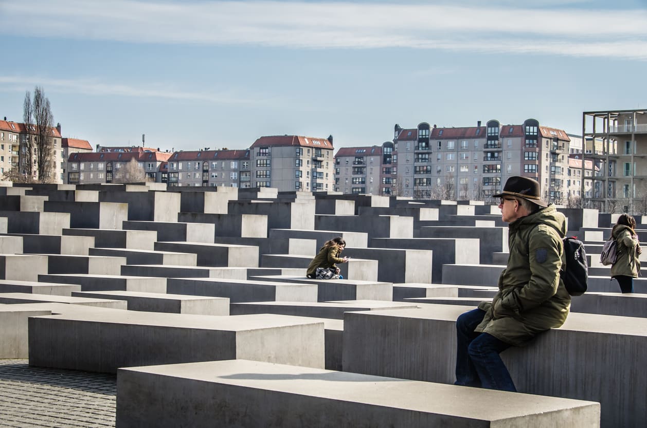 Memorial to the Murdered Jews of Europe in Berlin, featuring concrete slabs with people quietly reflecting in the space.