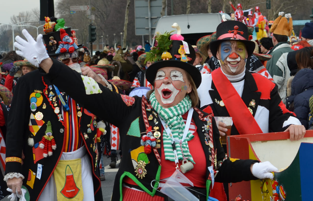 Revelers in vibrant costumes and makeup bring energy to the lively Carnival Monday parade in Düsseldorf, Germany.