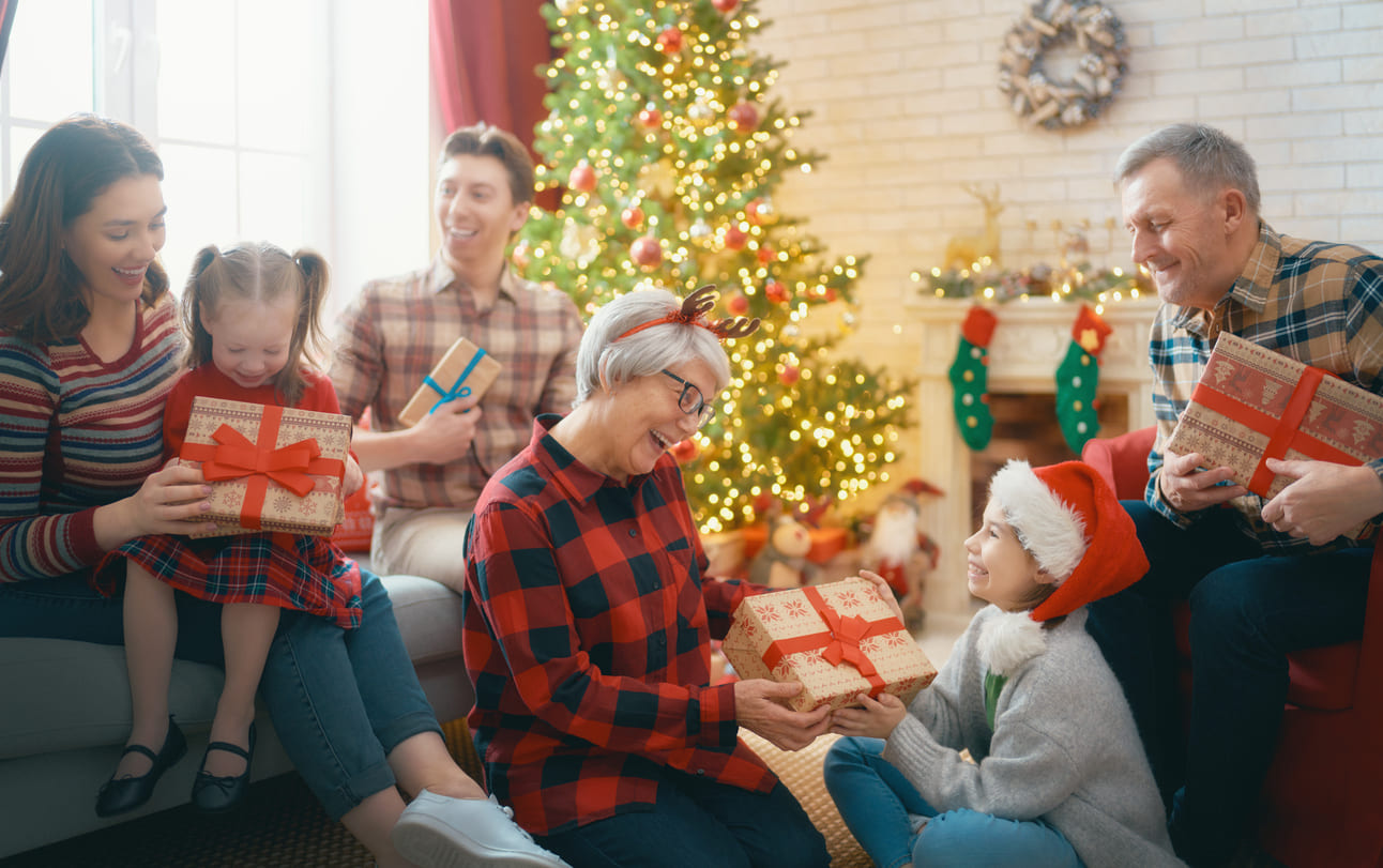 A family joyfully gathers around a glowing Christmas tree, engaging in the cherished tradition of gift exchange (Bescherung).