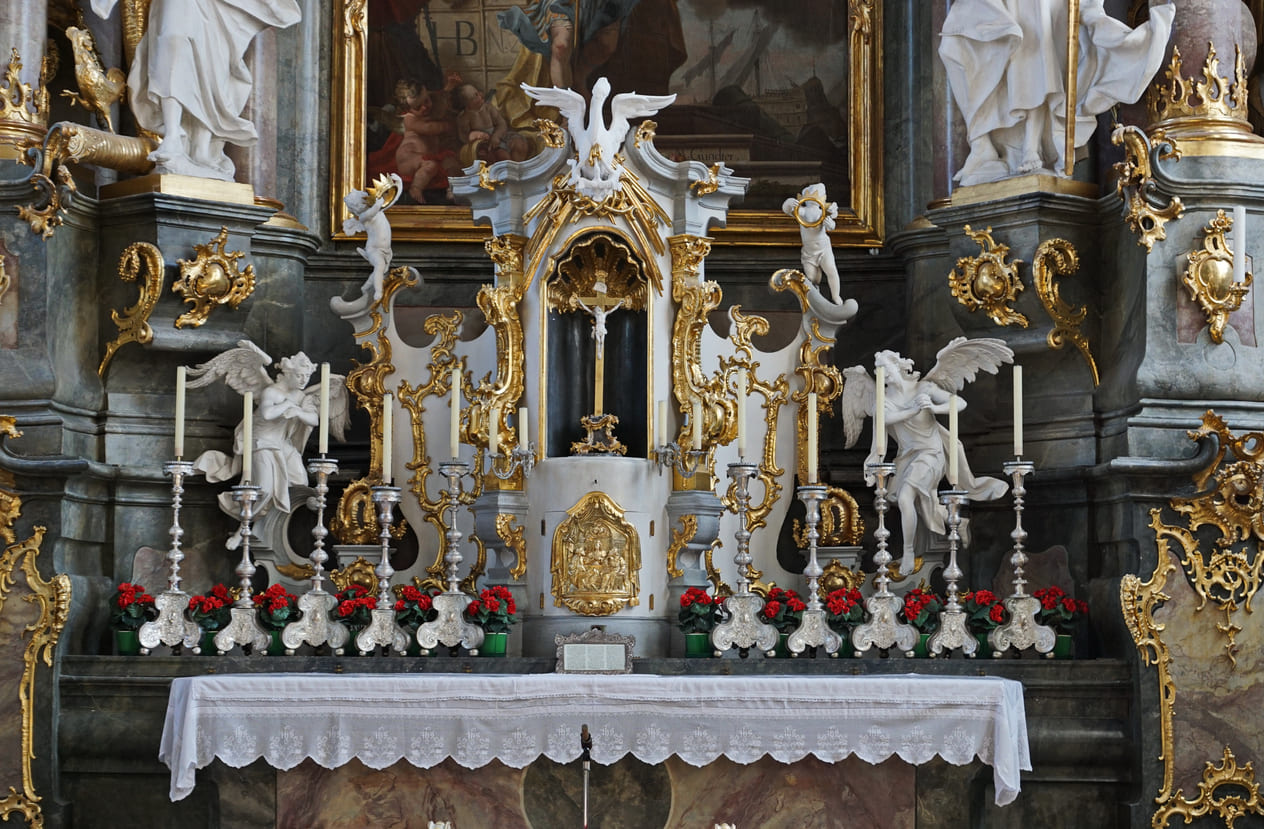 The ornate altar of St. Peter and Paul Church, adorned with intricate Baroque details, candles, and flowers, reflects a solemn and sacred atmosphere.