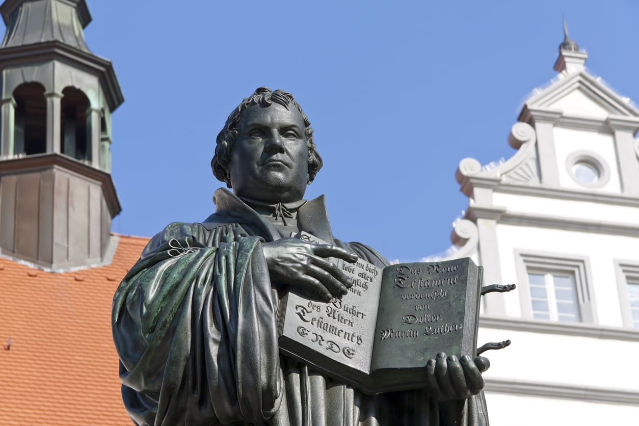 A statue of Martin Luther in Wittenberg, Germany, holding the Bible, symbolizing his pivotal role in the Protestant Reformation.