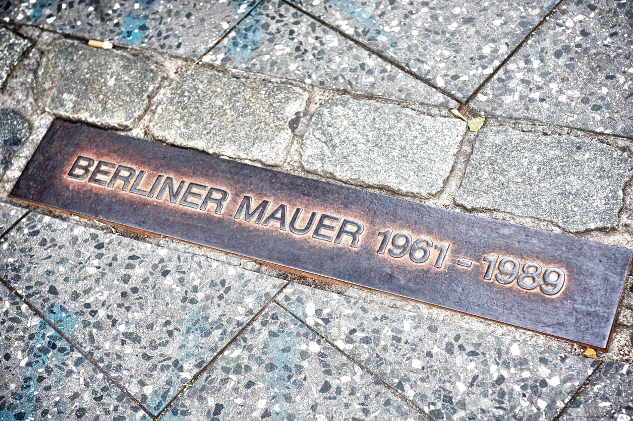 A street plaque marking the Berlin Wall (1961–1989), symbolizing the division and repression of East Germany under the SED regime.