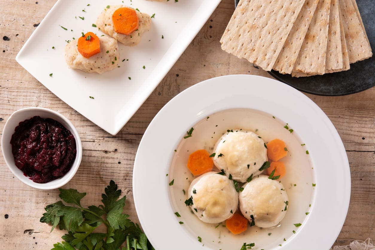 A traditional Sukkot meal showcasing matzo ball soup, matzo crackers, and festive accompaniments.