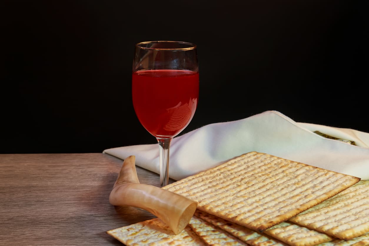 Passover essentials, including matzah, wine, and a symbolic cloth, reflecting the holiday's traditions and significance.