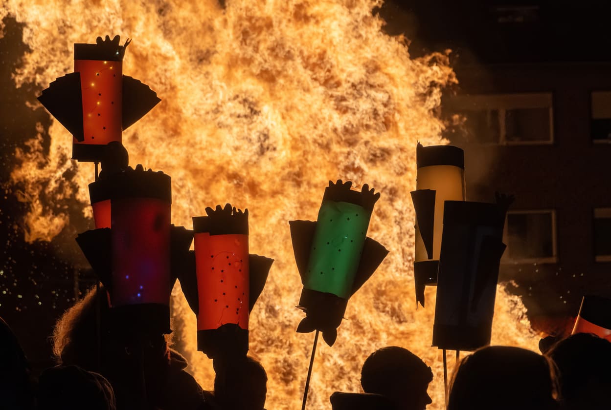 Lanterns held by children shine brightly against a blazing Martinsfeuer, symbolizing the warmth and unity of St. Martin's Day.