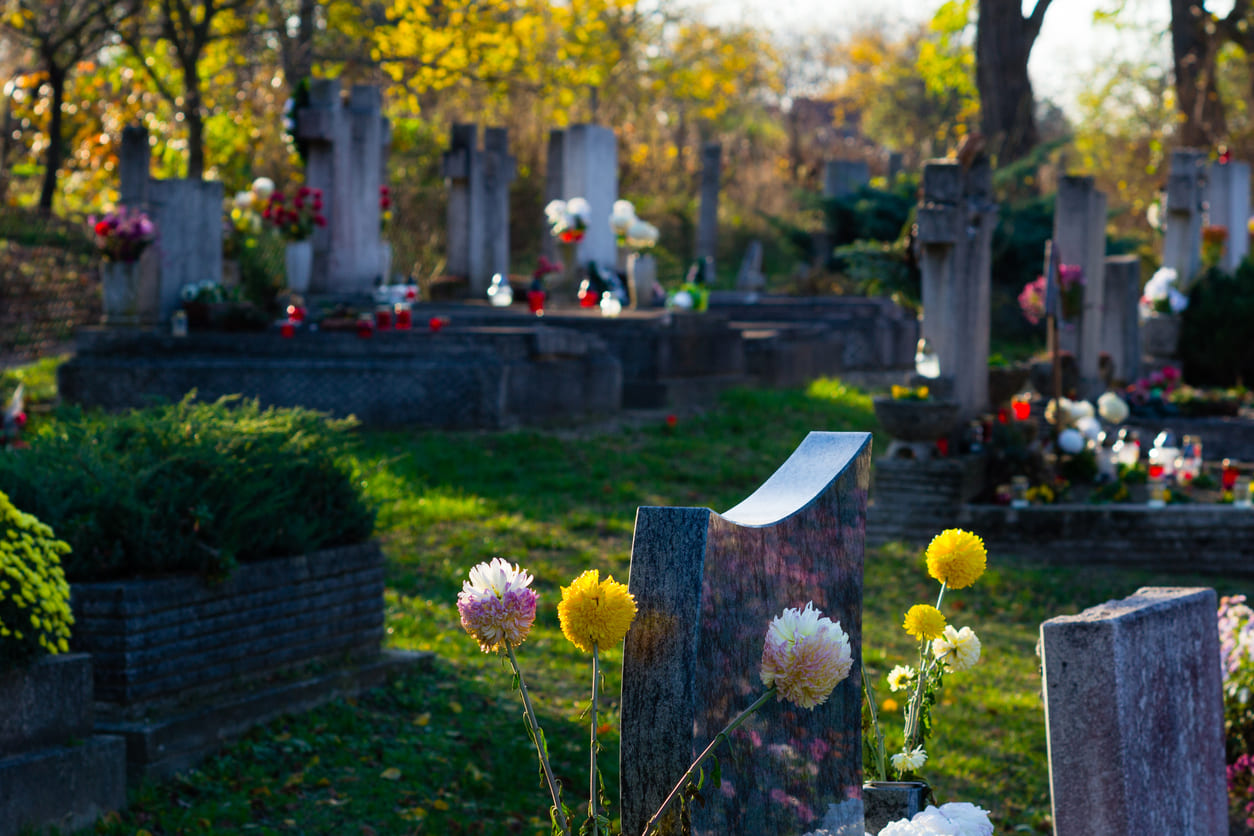 A serene cemetery with gravestones and fresh flowers, evoking reflection and remembrance on Sunday of the Dead.