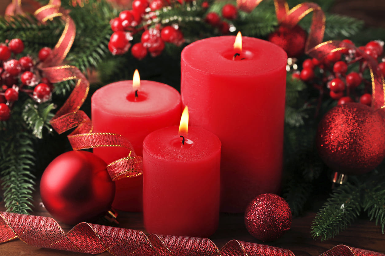 Three red candles glowing on an Advent wreath, representing the joy of the Third Advent Sunday.