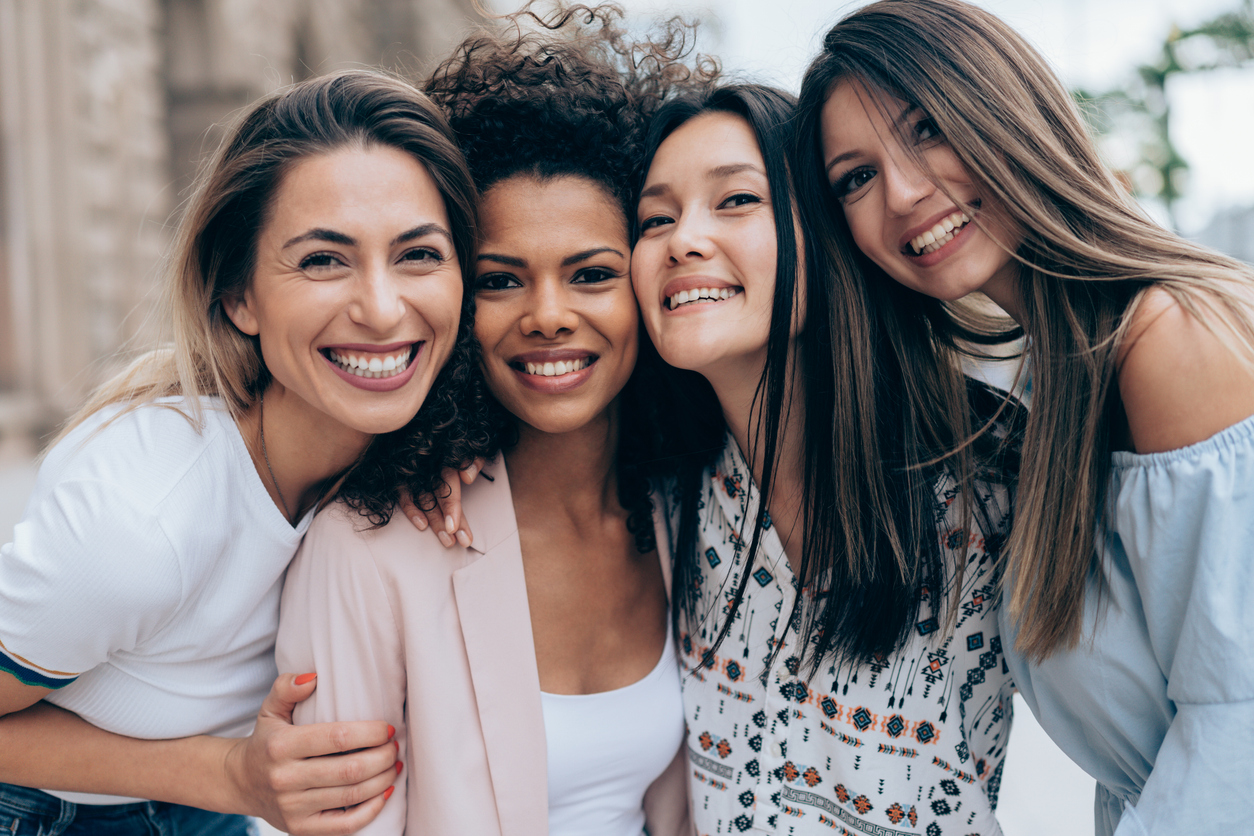 A diverse group of women smiling together, symbolizing unity, joy, and empowerment.