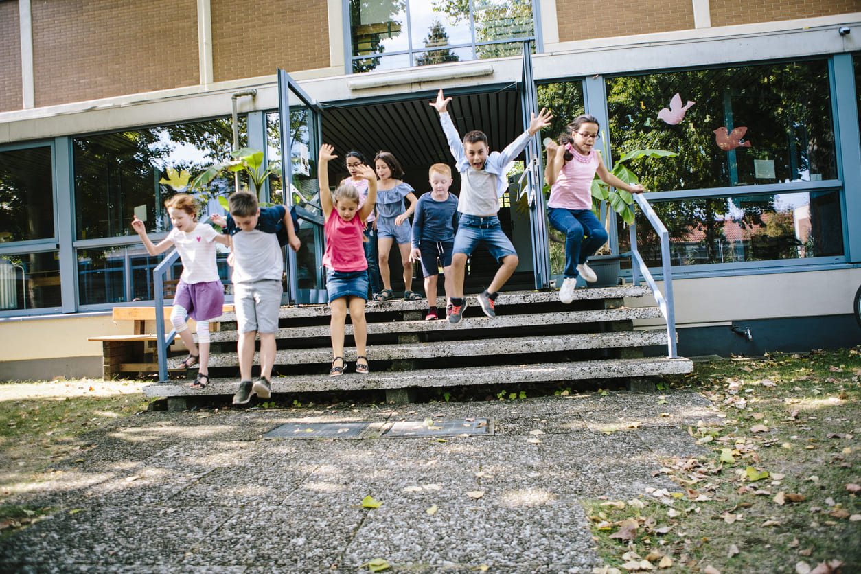 A group of children happily jumping down steps, capturing their energy and joy in a playful moment.