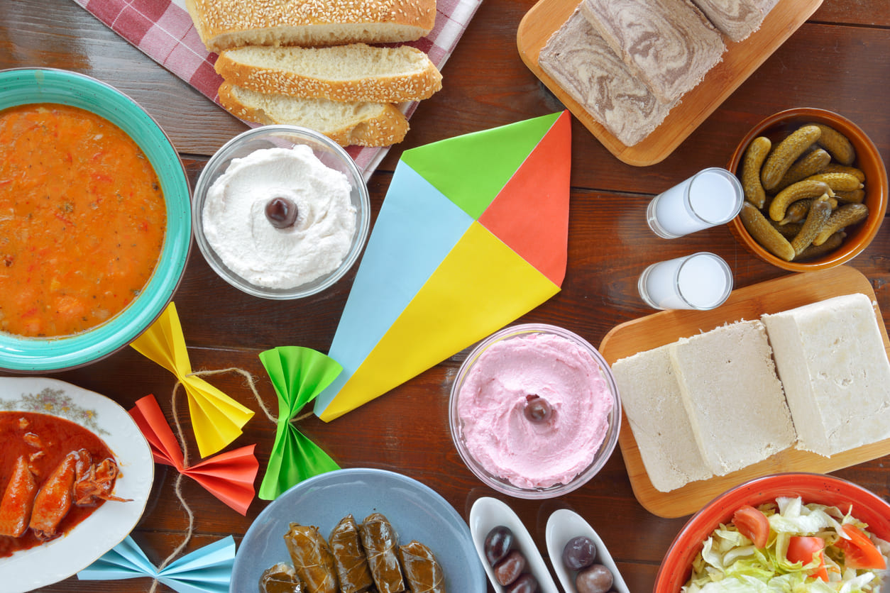 Clean Monday table shows Lenten dishes, lagana bread, and a colorful paper kite, blending Greek tradition with festive spring spirit.