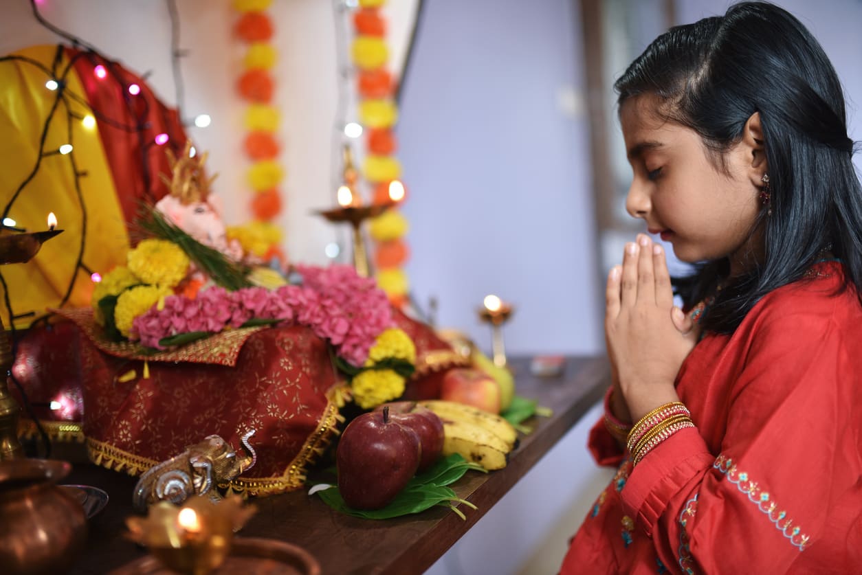 A young girl praying at a decorated altar, reflecting devotion and the spirit of Chaitra Sukhladi.