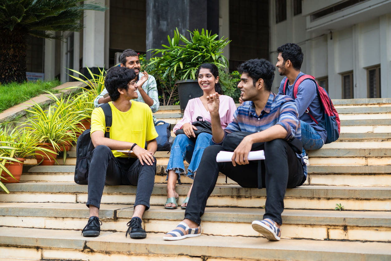 Group of friends sitting on steps, laughing and enjoying each other's company, symbolizing the joy of friendship.