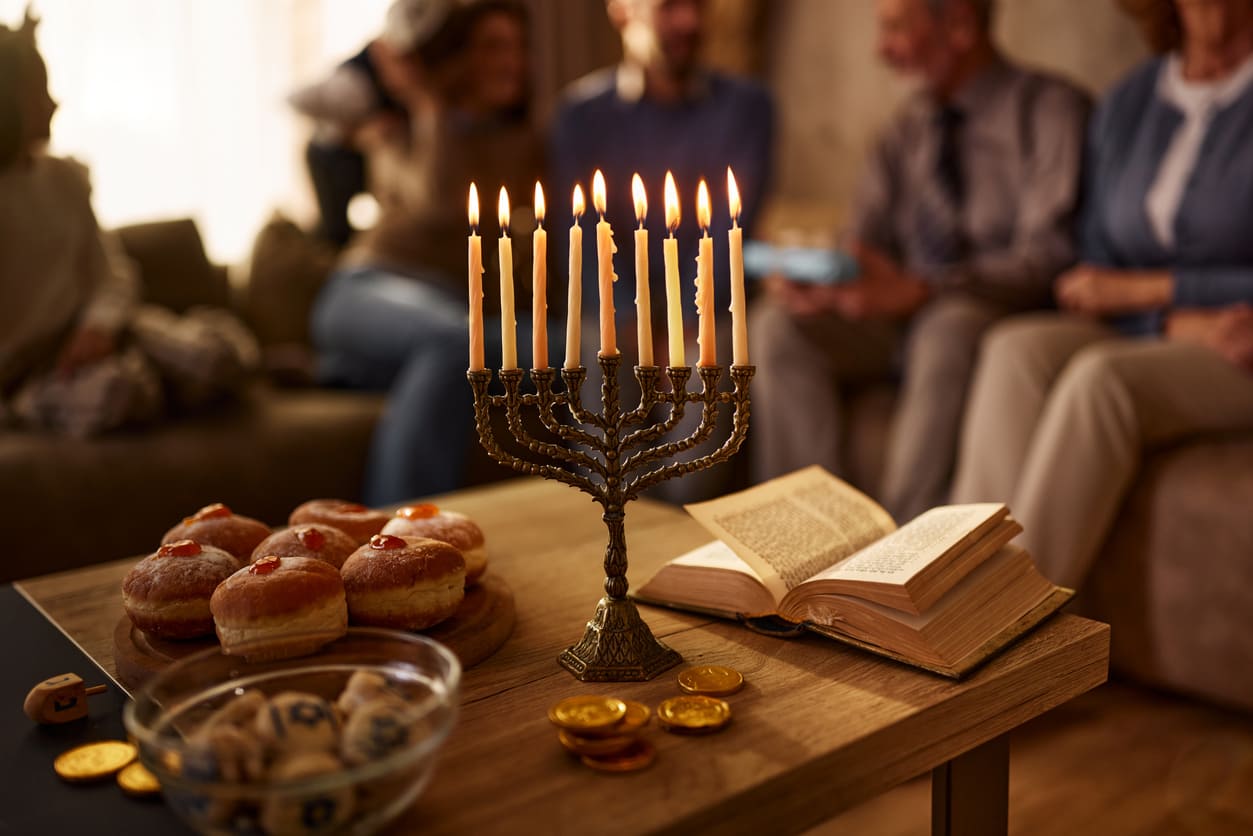 A glowing menorah, festive foods, and a family gathering symbolize the joyous celebration of the last day of Hanukkah.