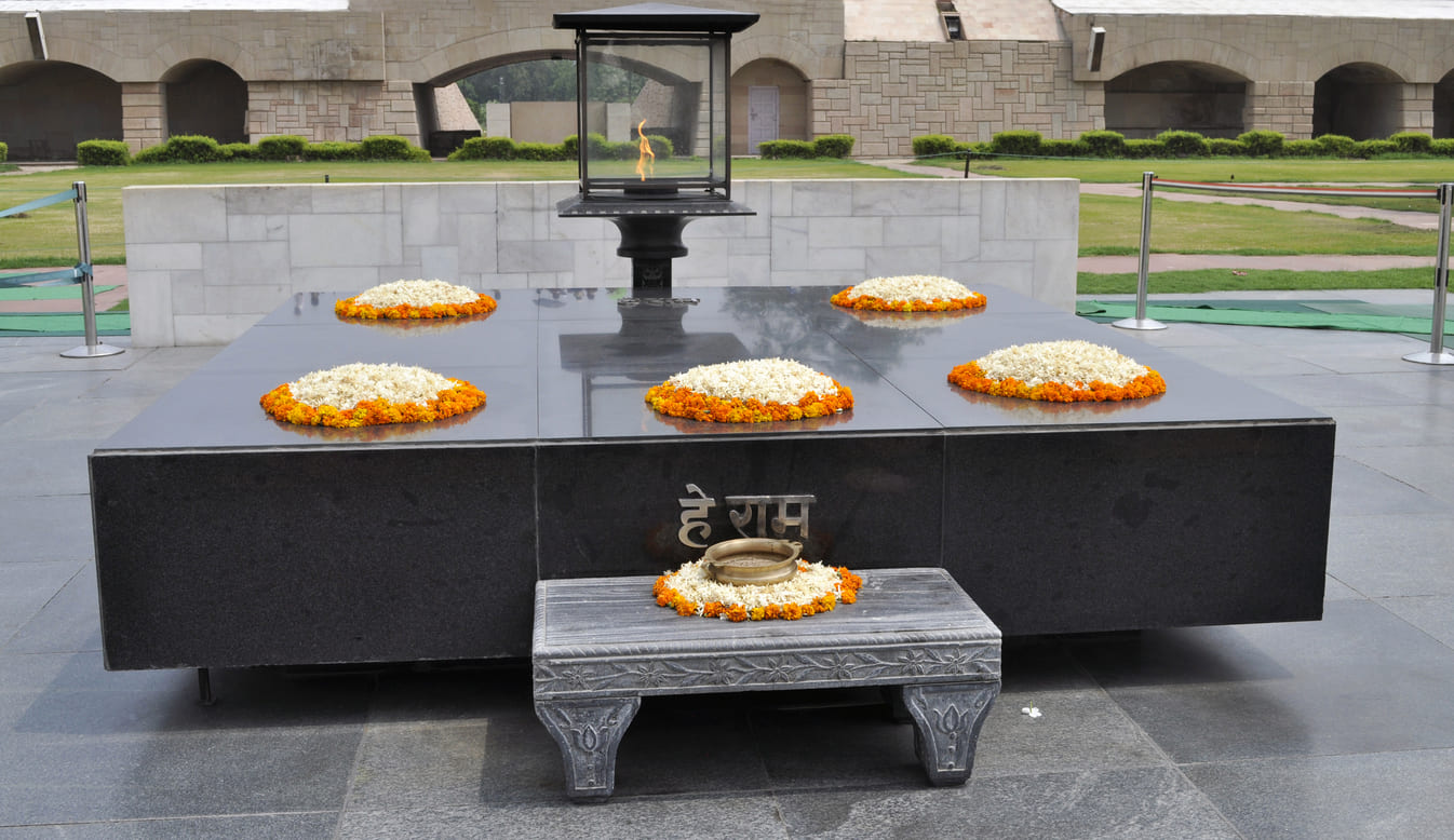 Mahatma Gandhi memorial, decorated with floral wreaths and an eternal flame symbolizing remembrance and reverence.