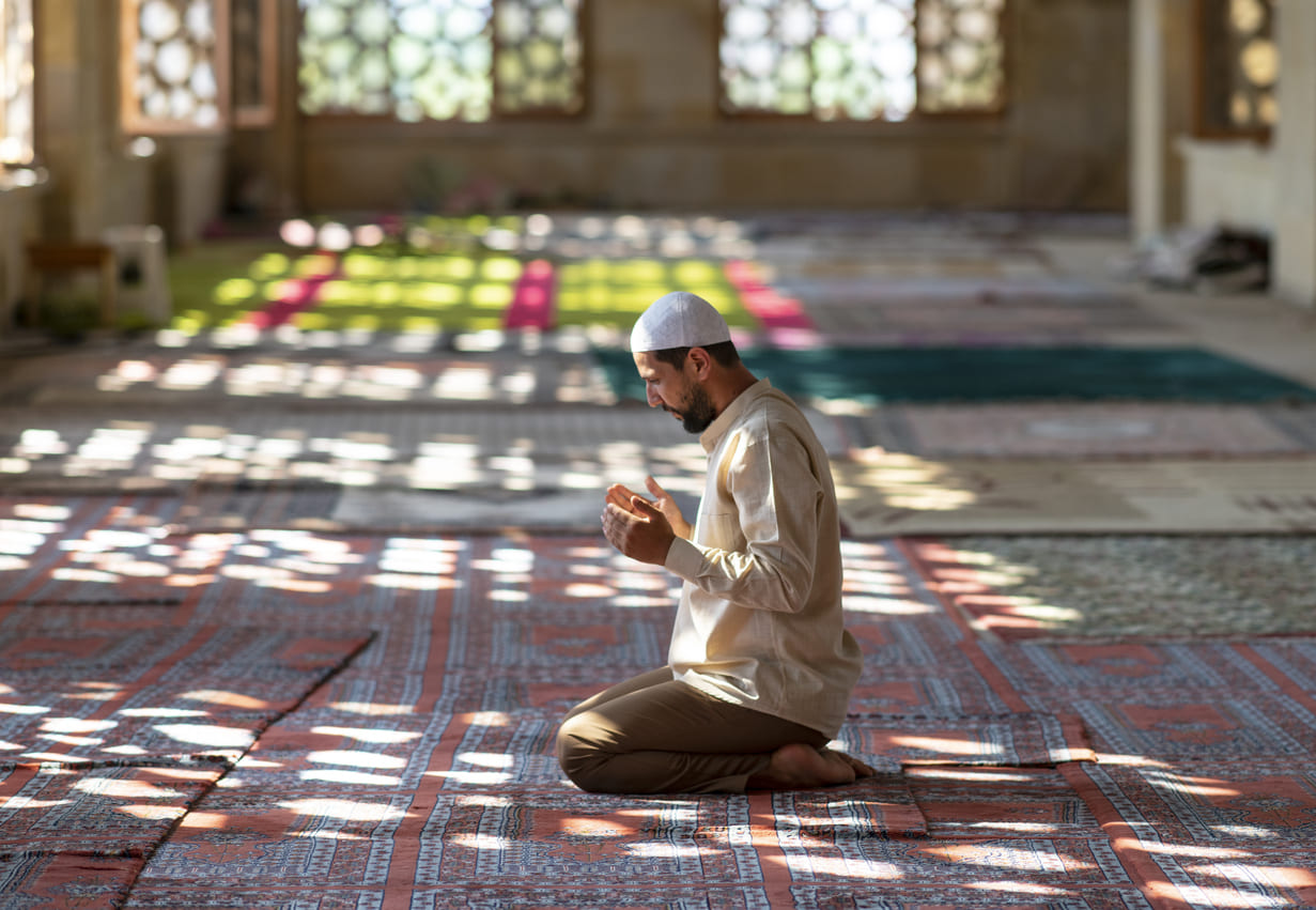 A worshiper in deep prayer inside a peaceful mosque, symbolizing devotion and spirituality.