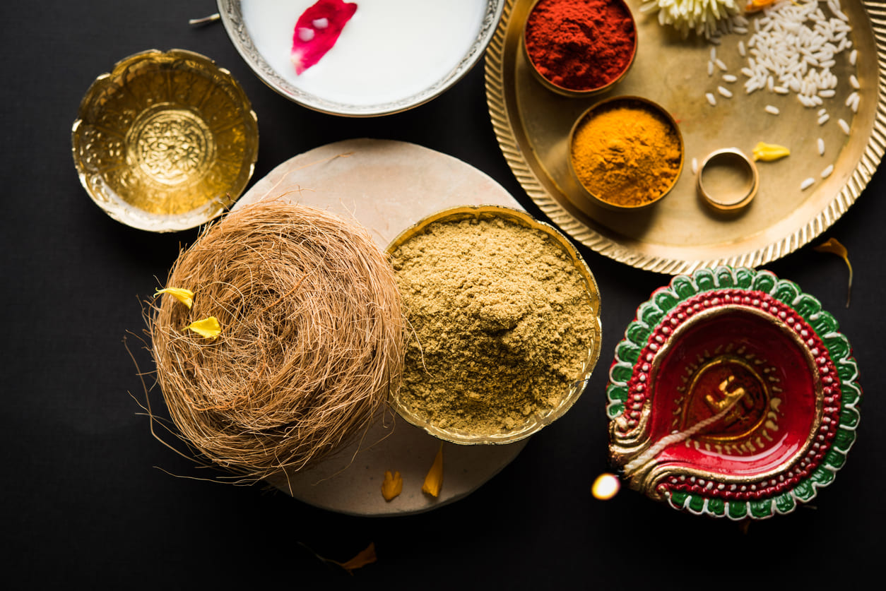 Essentials for the Abhyanga Snan ritual on Naraka Chaturdasi, featuring a diya, turmeric, kumkum, and ceremonial offerings.