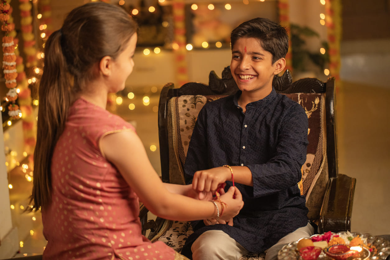 Sister tying a rakhi on her brother's wrist, symbolizing love, protection, and the cherished bond of Raksha Bandhan.