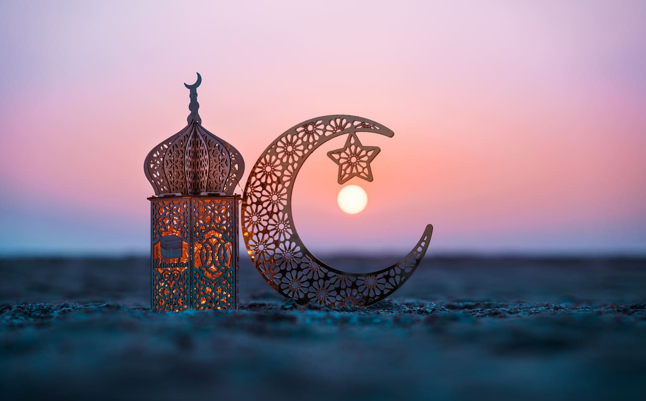 Ornate lantern and crescent moon with a star, set against a peaceful sunset, symbolizing the arrival of Ramadan.