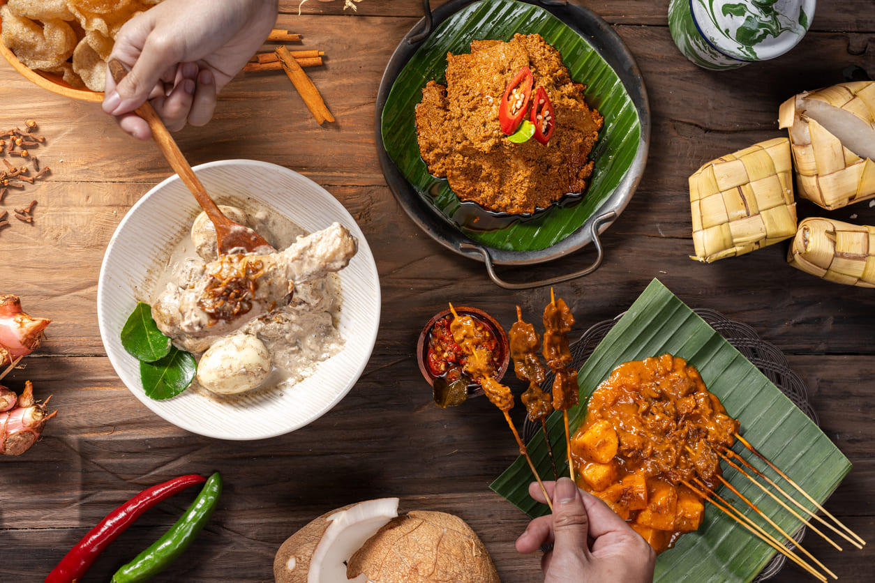 An inviting display of Indonesian festive dishes, featuring rendang, opor ayam, sate, and ketupat, prepared for joyful Idul Fitri family gatherings.
