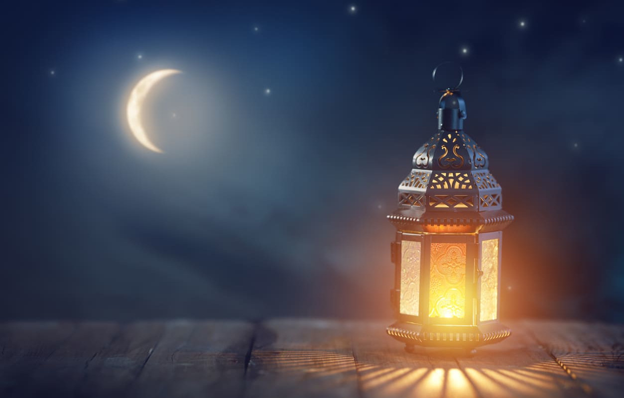 A serene image of a crescent moon and glowing lantern, capturing the symbolic start of Ramadan.