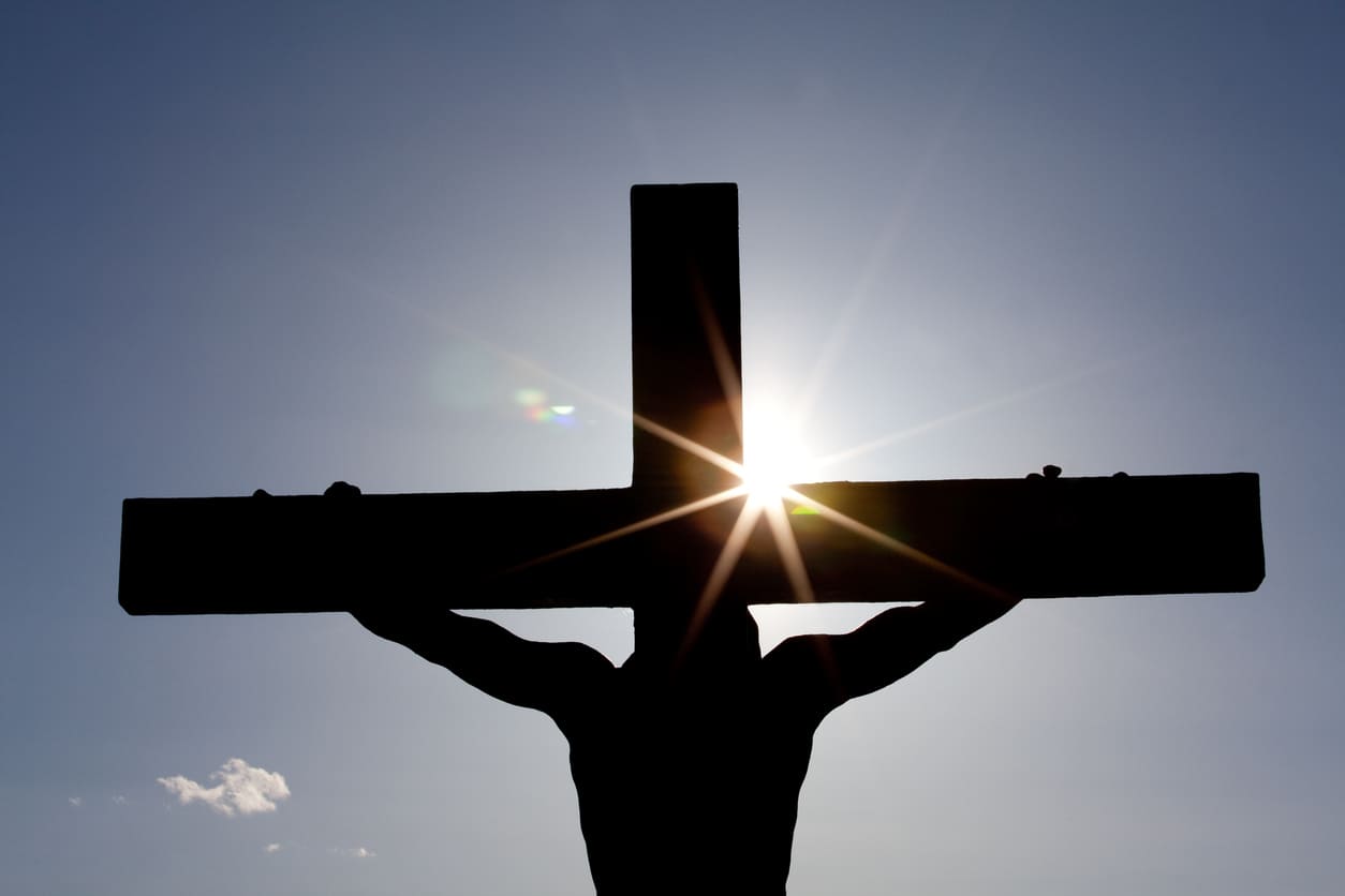 A silhouetted cross against the backdrop of the sun, symbolizing the solemnity and hope of Good Friday.