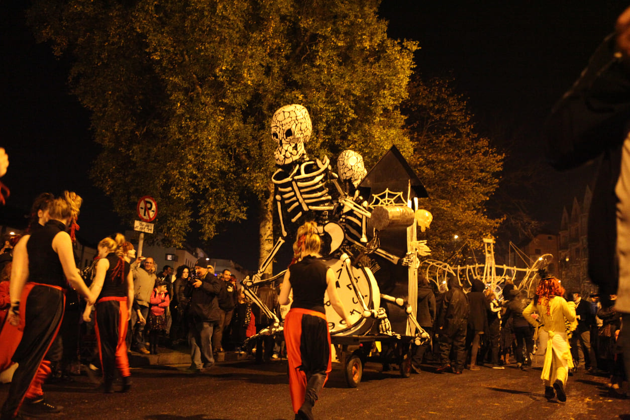 A vibrant Halloween parade with costumed participants and decorative floats, celebrating the October Bank Holiday in Ireland.