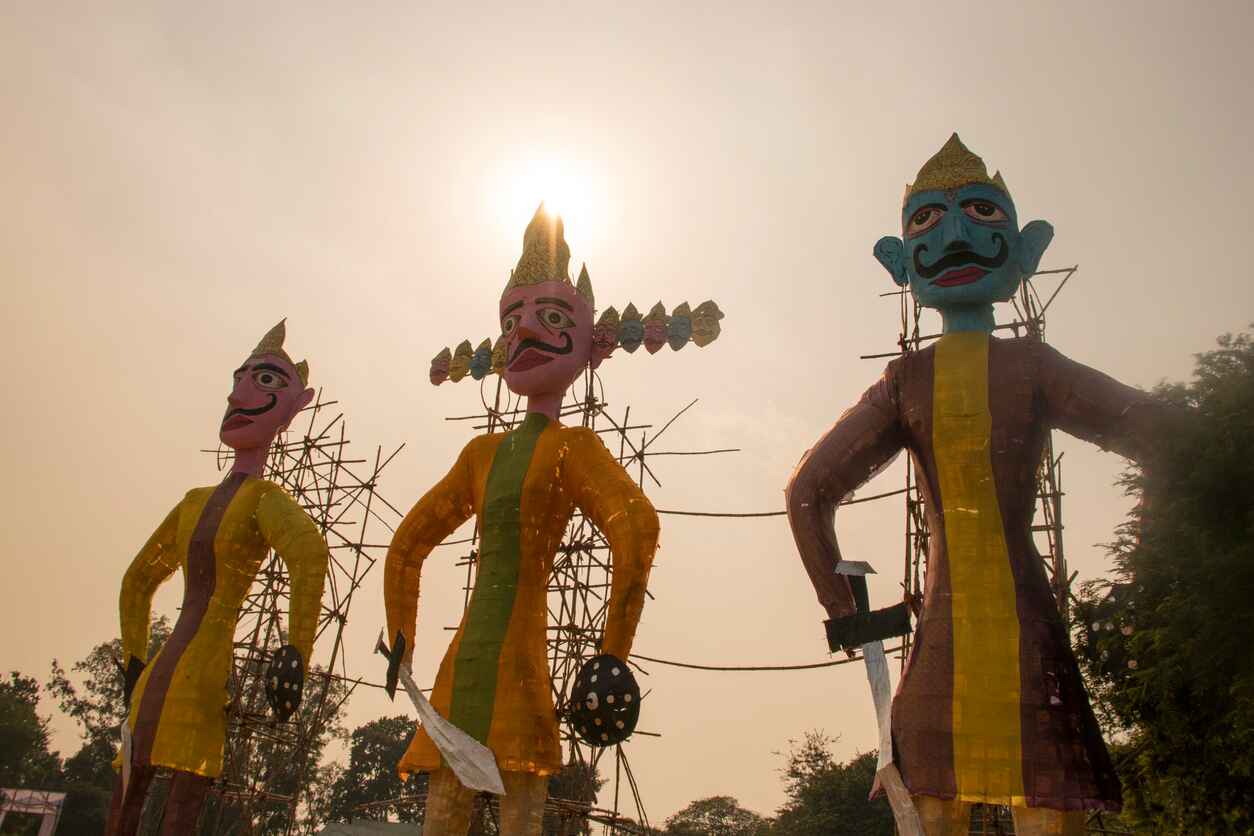 Large effigies of Ravana and his allies stand against the sky, prepared for the traditional Dussehra burning that marks the victory of good over evil.