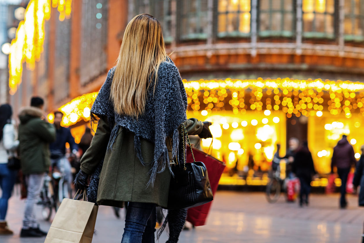 A festive street scene with glowing lights and shoppers enjoying the holiday spirit on Second Christmas Day.