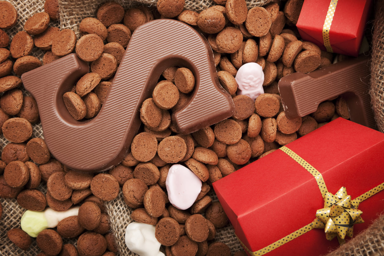 A festive display of pepernoten, chocolate letters, and wrapped gifts celebrating St. Nicholas' Day traditions.