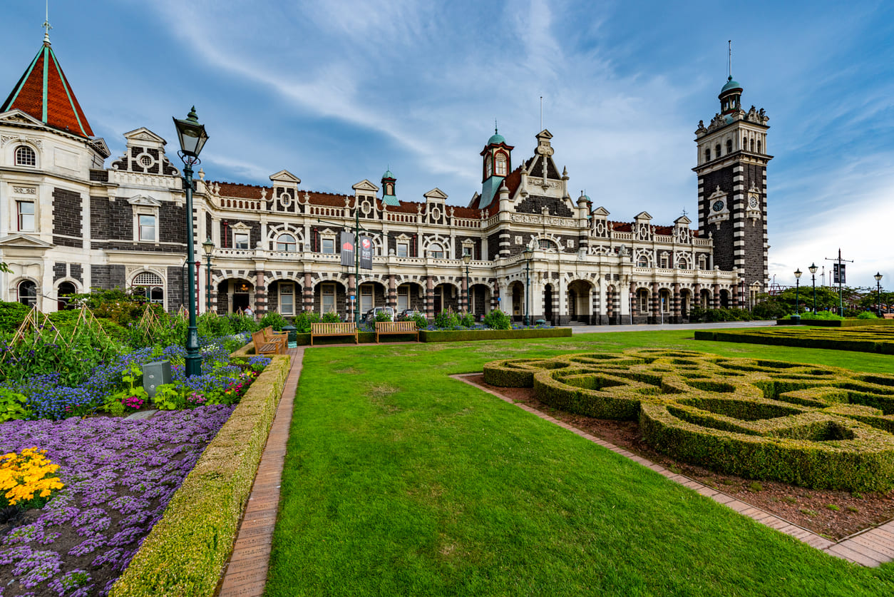 A vibrant view of the historic Dunedin Railway Station and its gardens, reflecting Otago's rich architectural and cultural heritage.