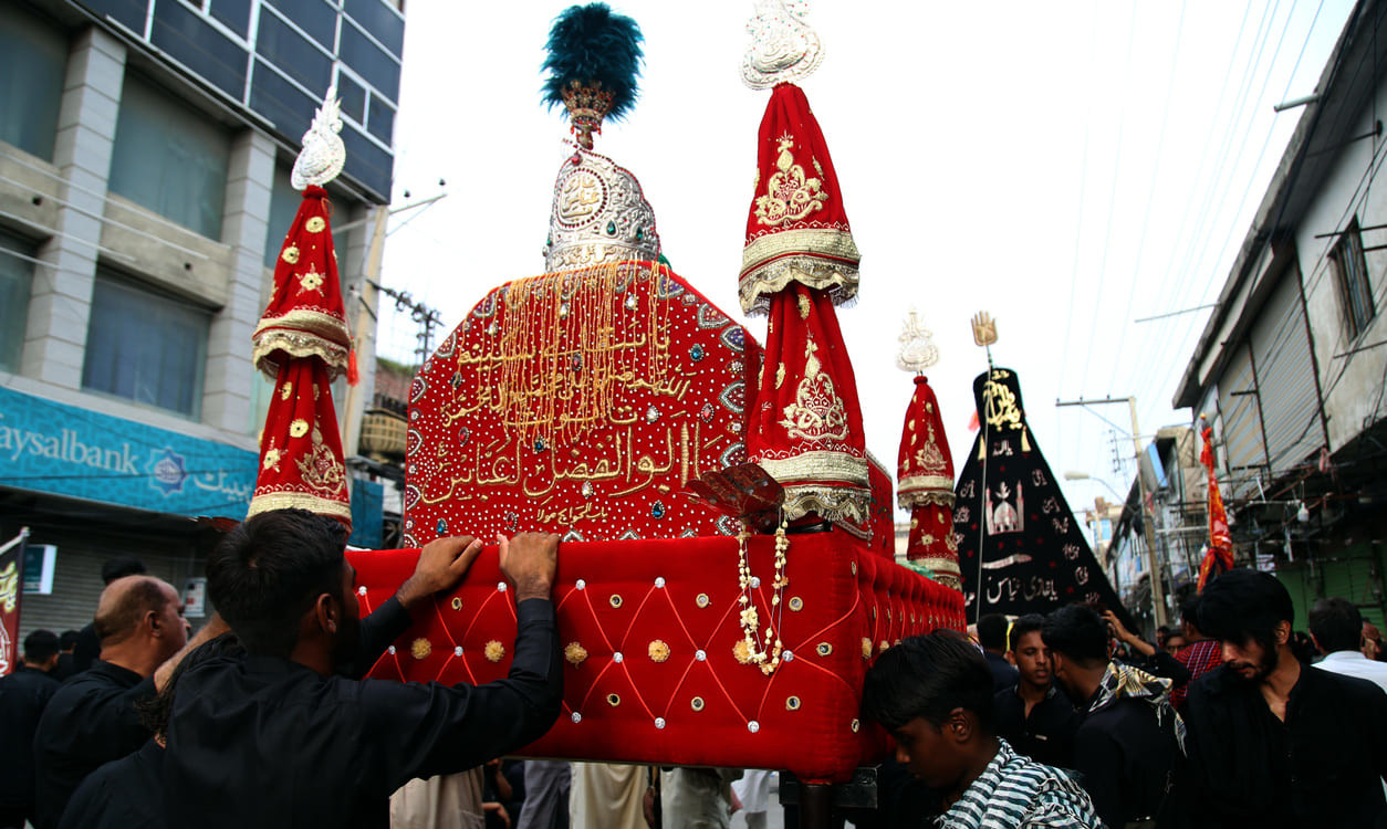 A Chehlum procession in Pakistan, with participants carrying a beautifully adorned Tazia to commemorate the sacrifices of Imam Hussain.