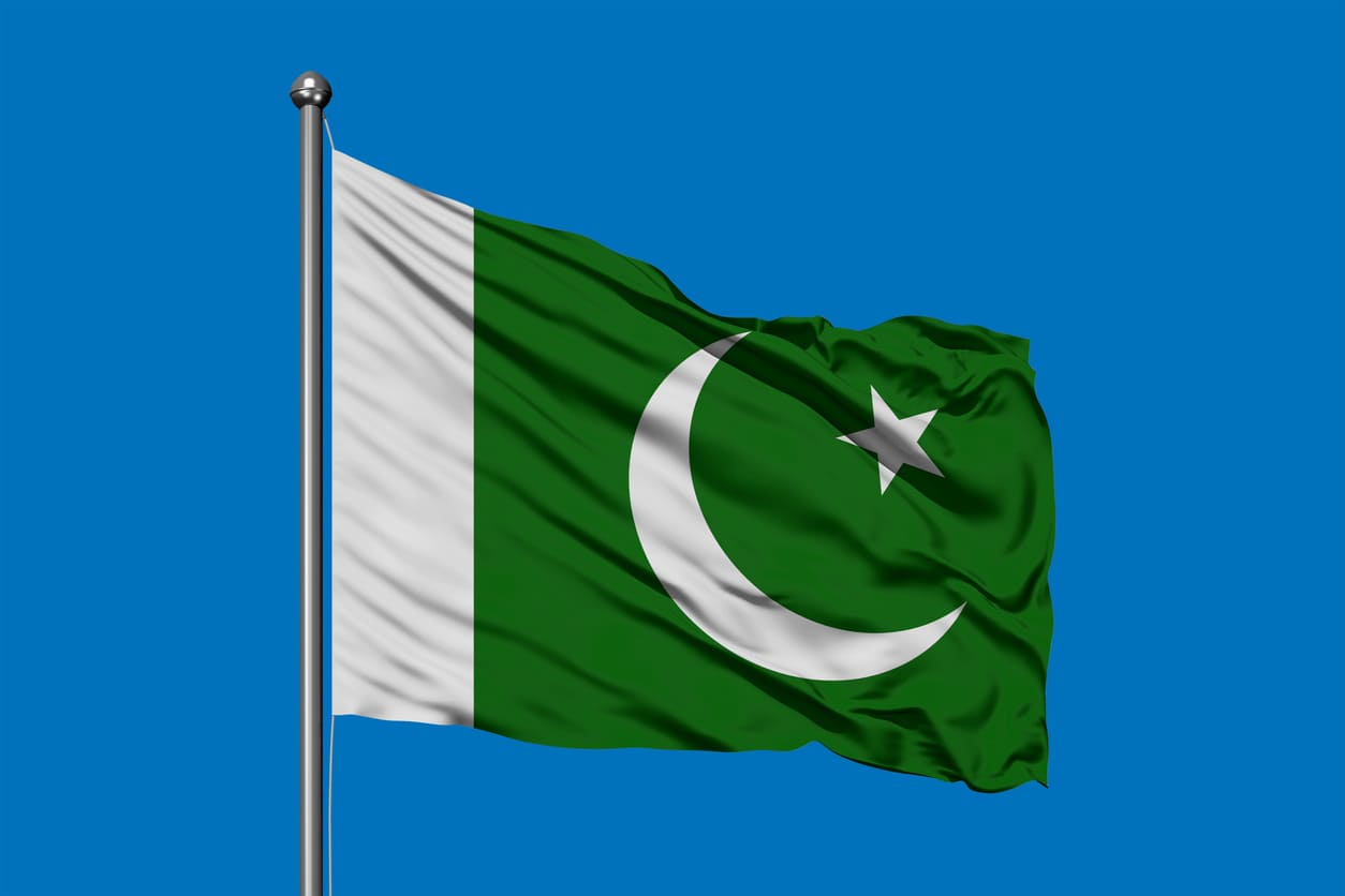 Pakistan's national flag waving against a clear blue sky, symbolizing pride, independence, and national unity.