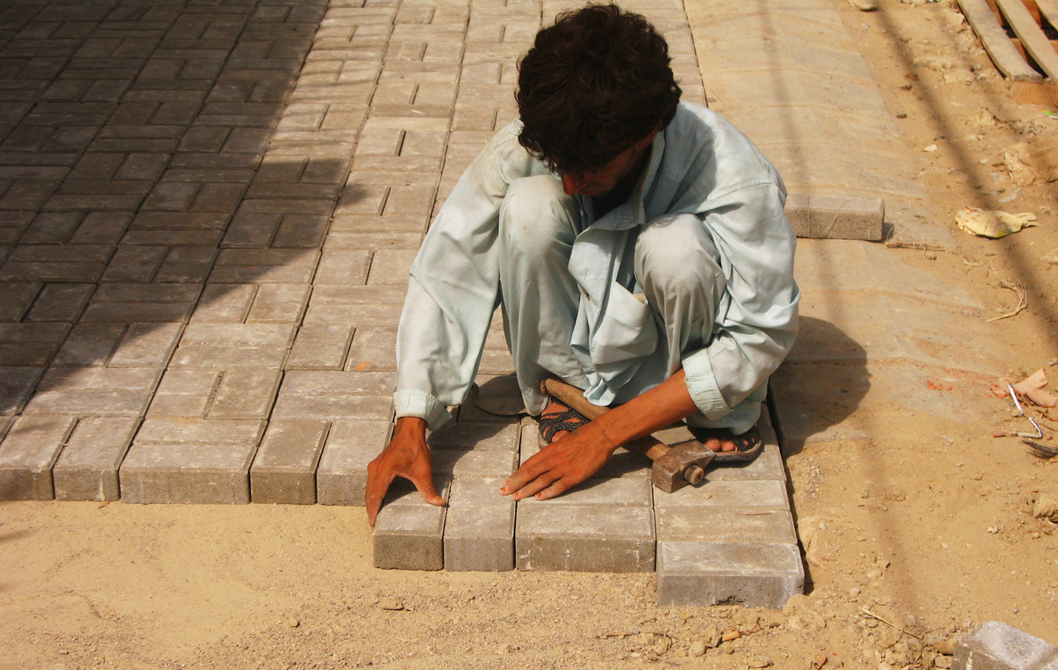 A laborer meticulously laying bricks, symbolizing the dedication and hard work celebrated on Labour Day.