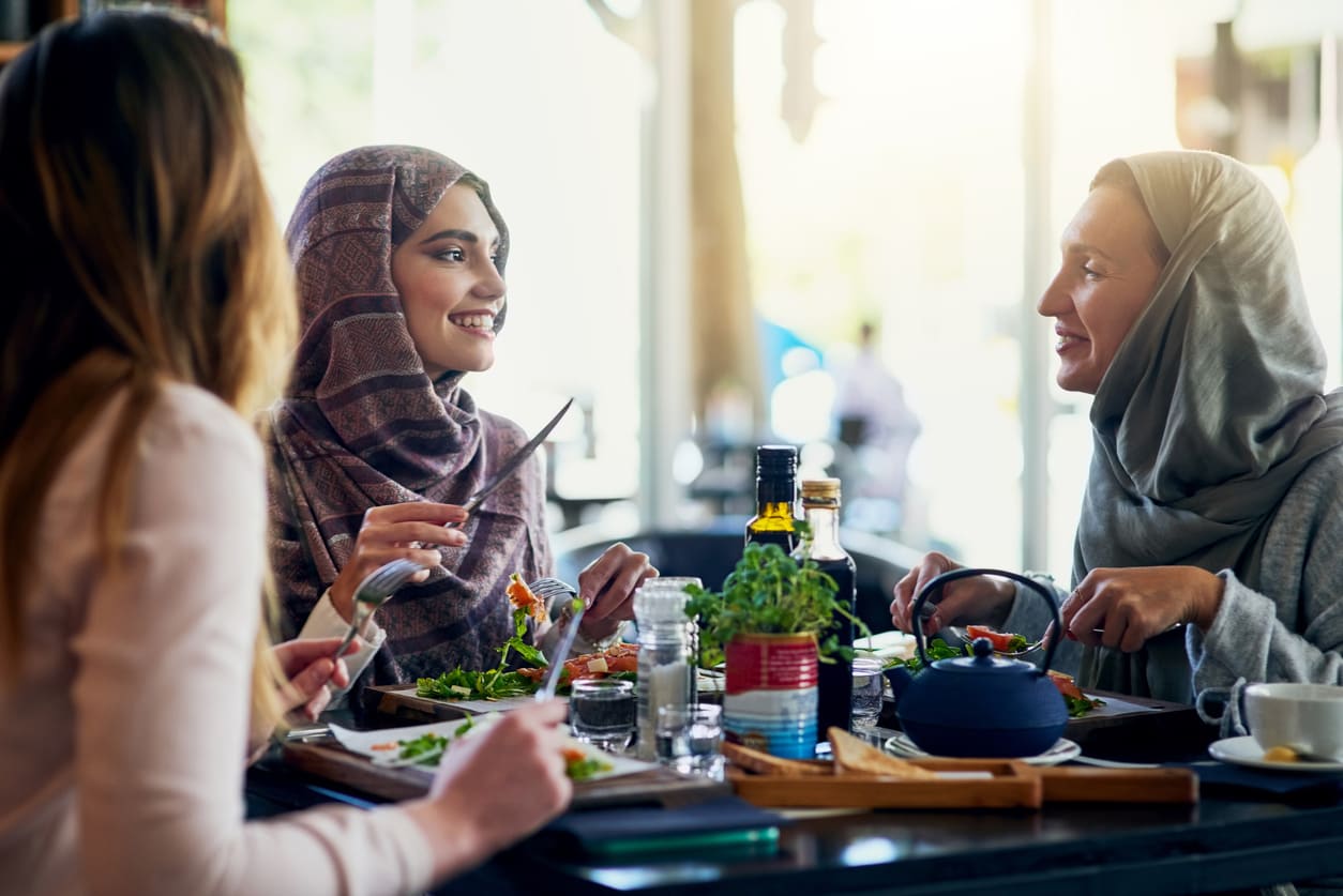 Friends enjoying a meal and sharing joyful moments, symbolizing togetherness and celebration.